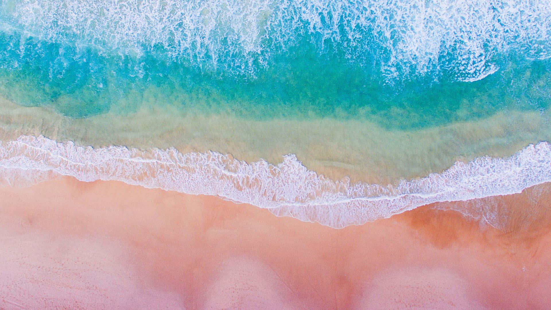 A breathtaking view of Pink Beach, where turquoise waters meet rosy sands. Wallpaper
