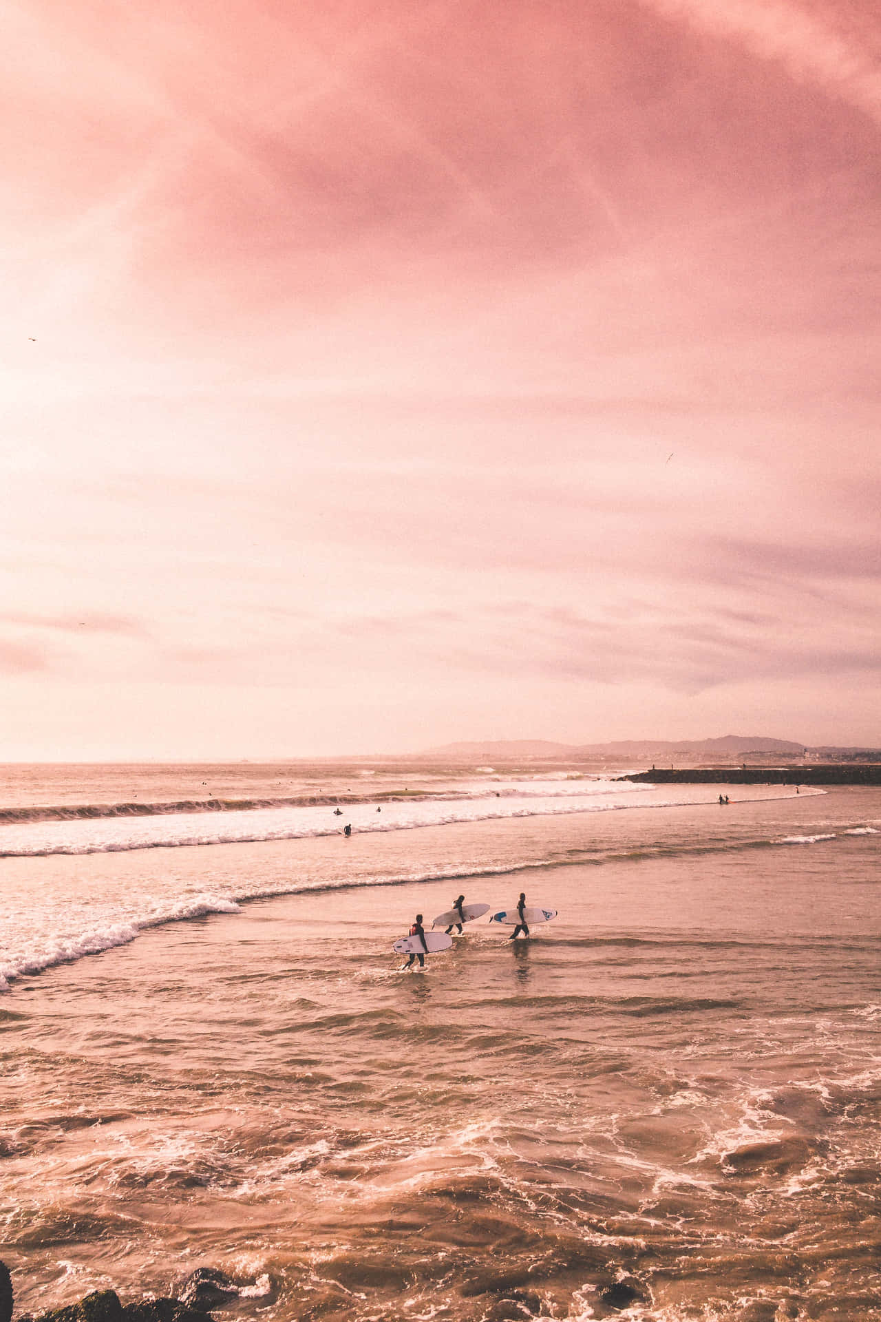 En gruppe mennesker surfer i havet. Wallpaper