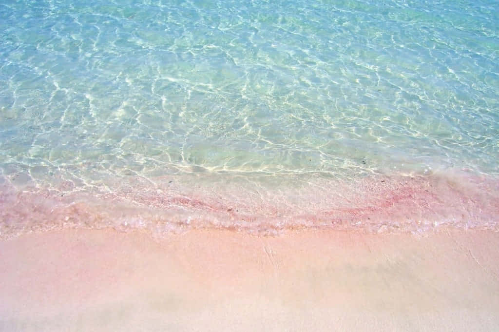 A Beach With Pink Sand And Water Wallpaper