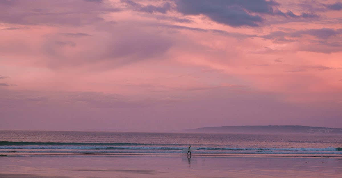 Enjoying a warm and beautiful evening on the beach with a peaceful pink aesthetic. Wallpaper