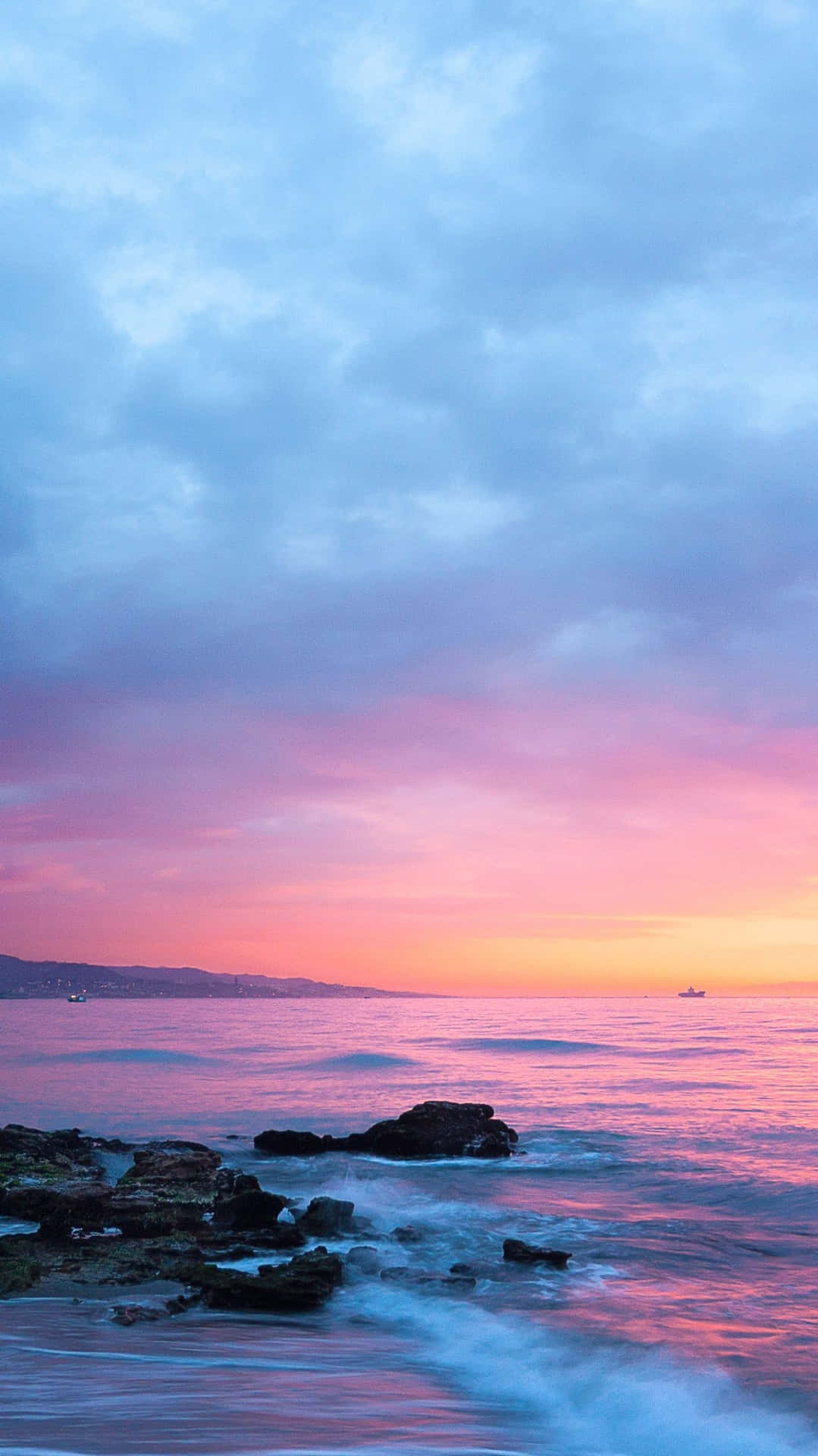 Pink Beach Sunset With Waves Hitting Rocks Wallpaper