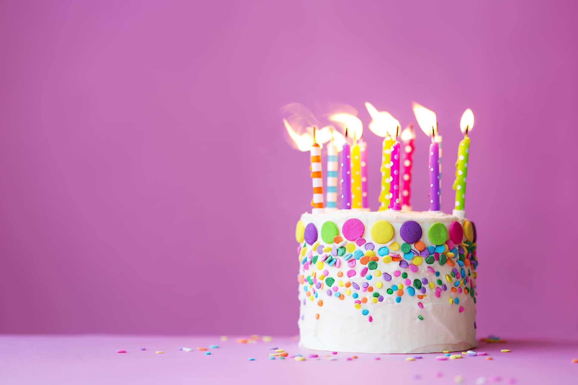 a birthday cake with candles on a purple background