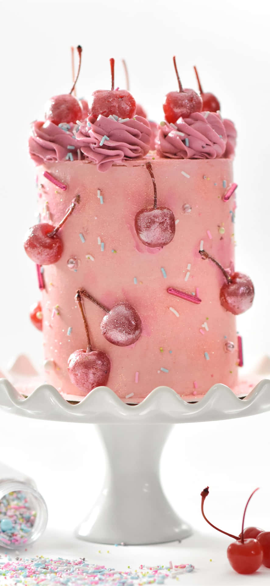 A Pink Cake With Cherries On Top Wallpaper