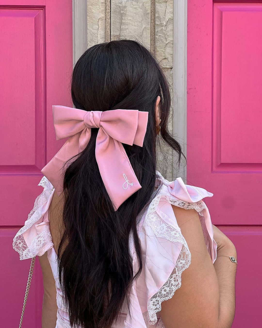 Pink Bow Hair Accessory Against Pink Door Wallpaper