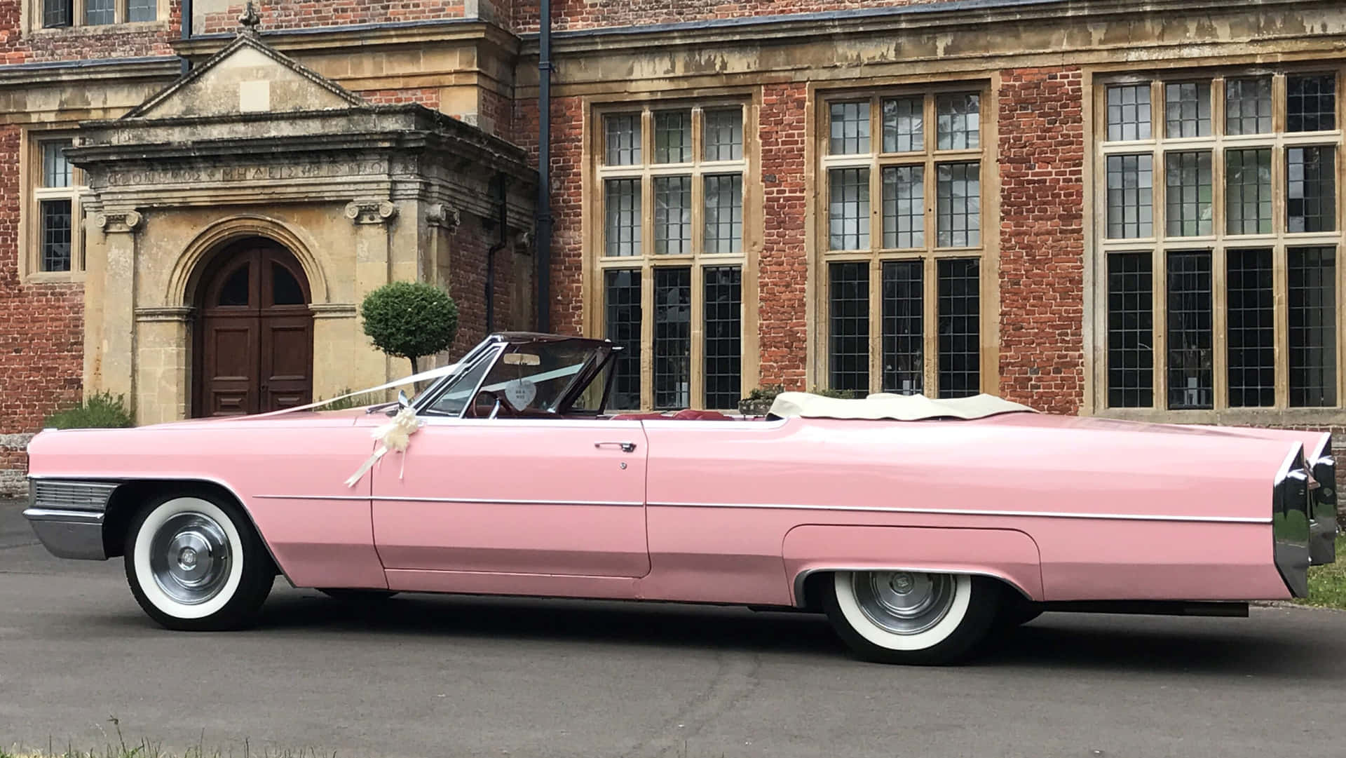 Classic Pink Cadillac under a Sunset Sky Wallpaper