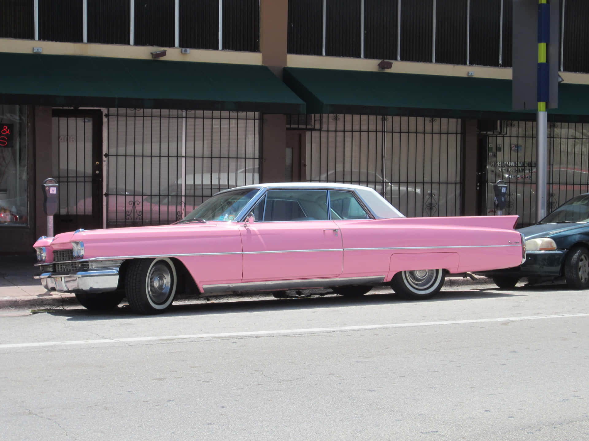 A Stunning Pink Cadillac Gleaming in the Sun Wallpaper
