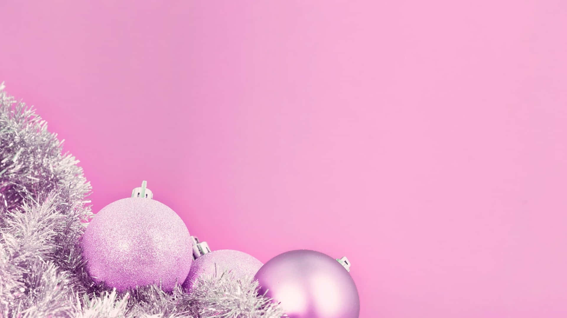 A Pink Christmas Tree With Silver Ornaments On It