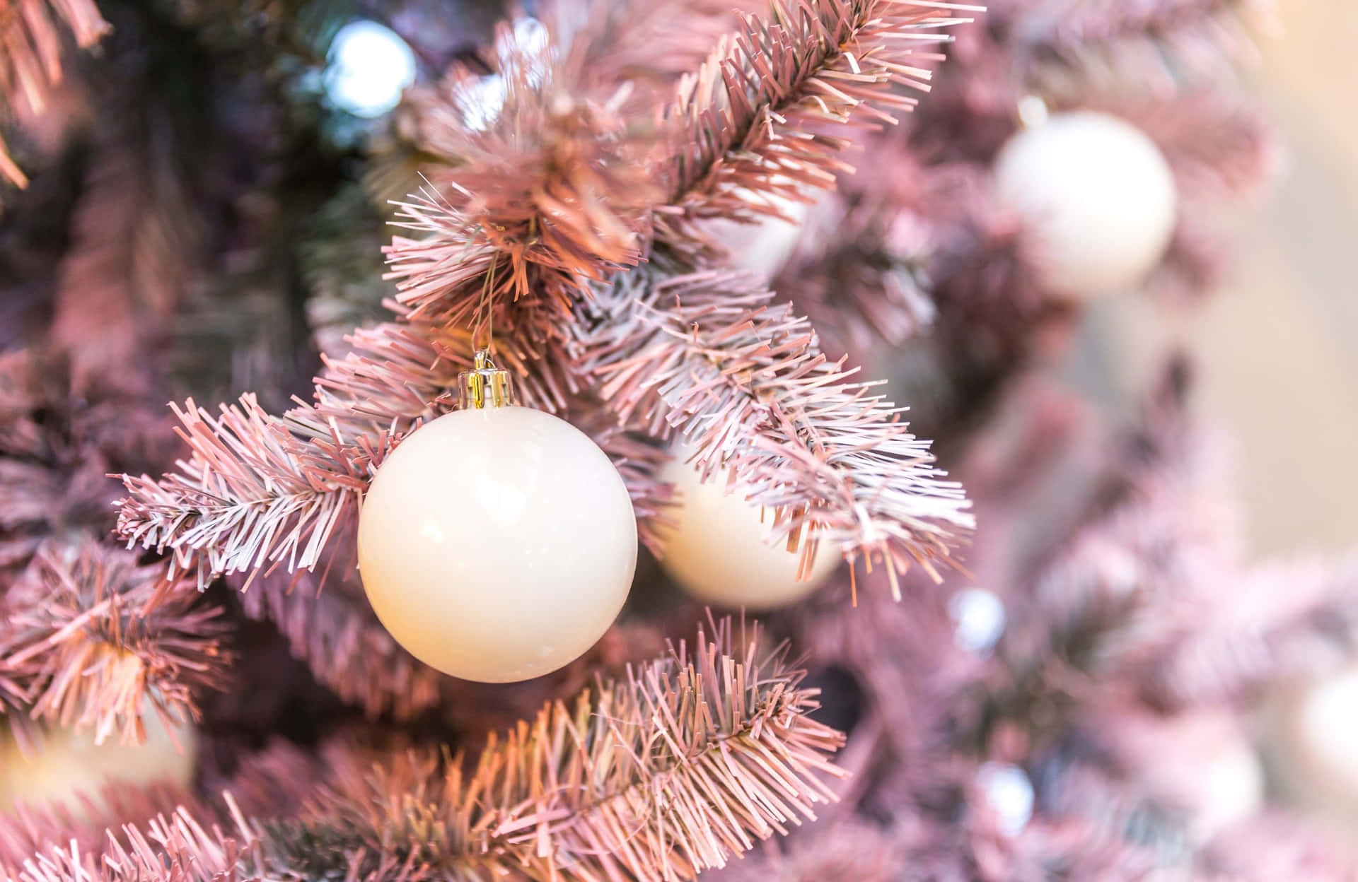 A Pink Christmas Tree With White Balls On It