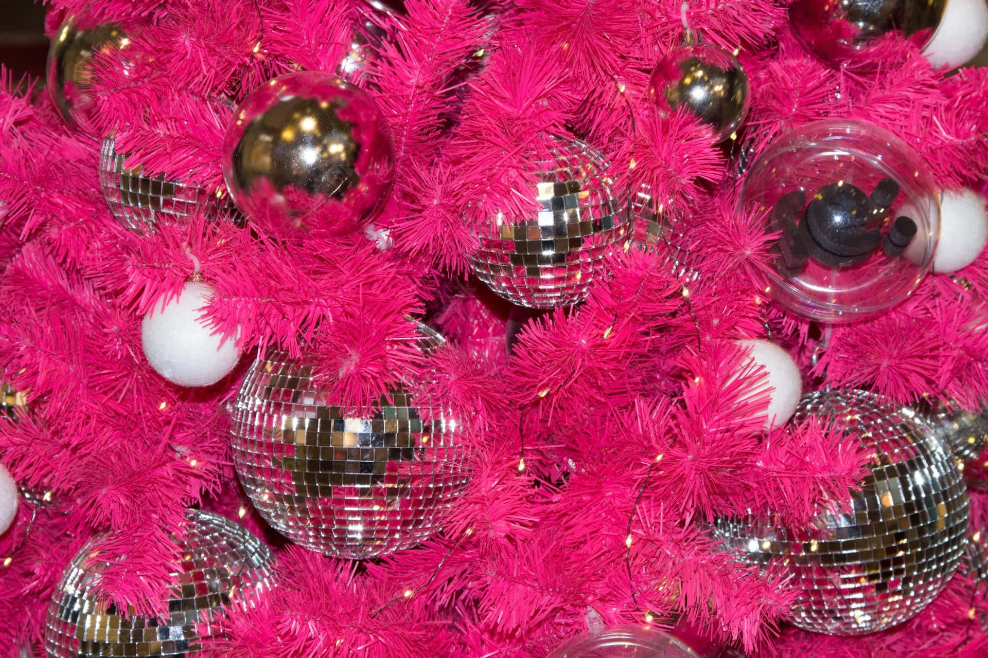 A Pink Christmas Tree With Disco Balls And Silver Ornaments Wallpaper