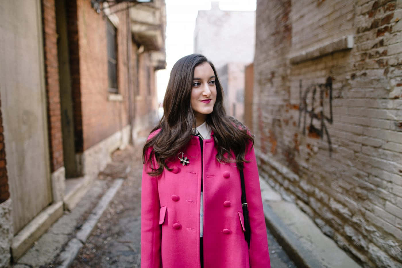 Stylish woman in a pink coat posing confidently Wallpaper
