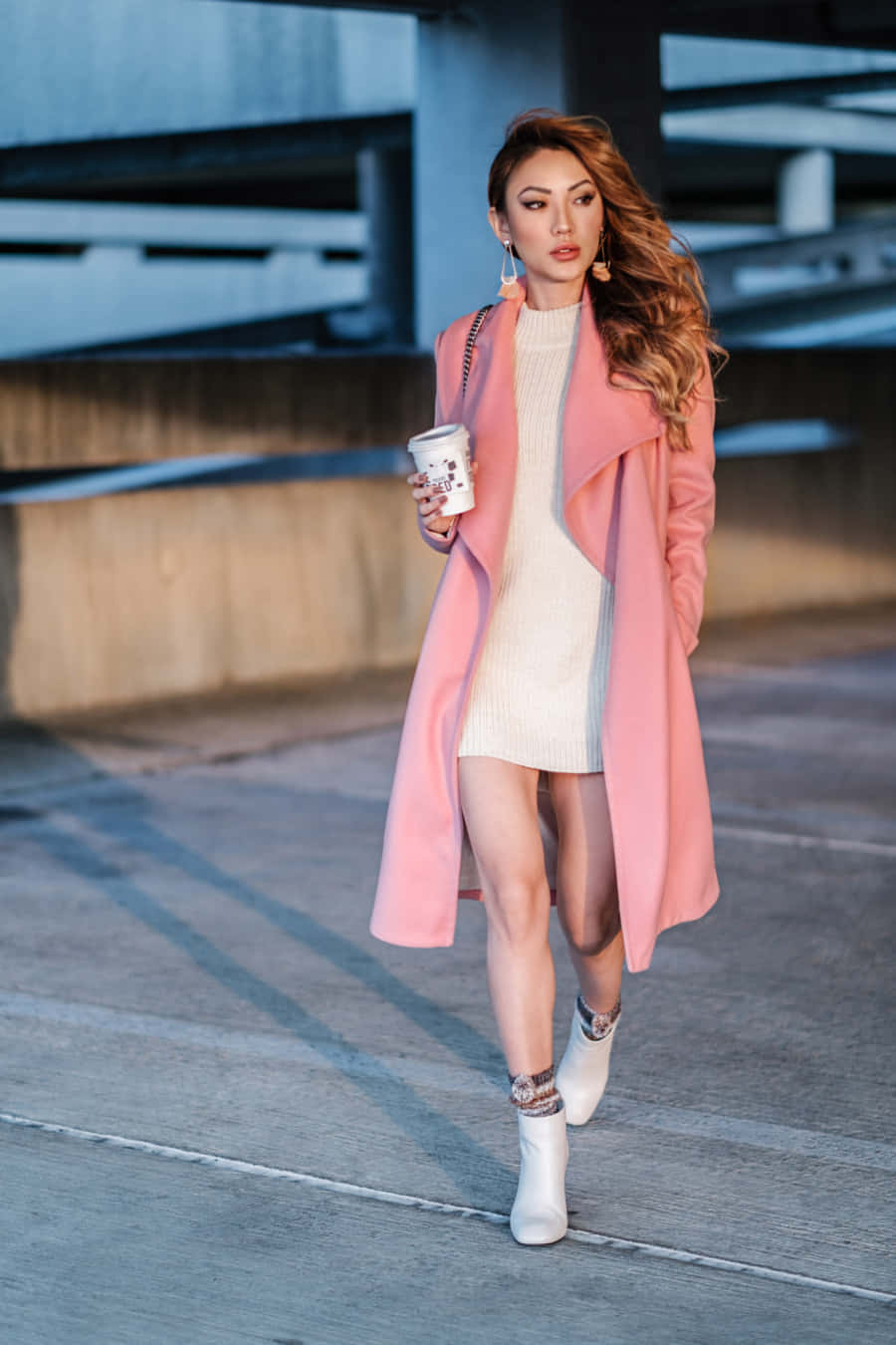 Stylish female in pink coat strolling outdoors Wallpaper