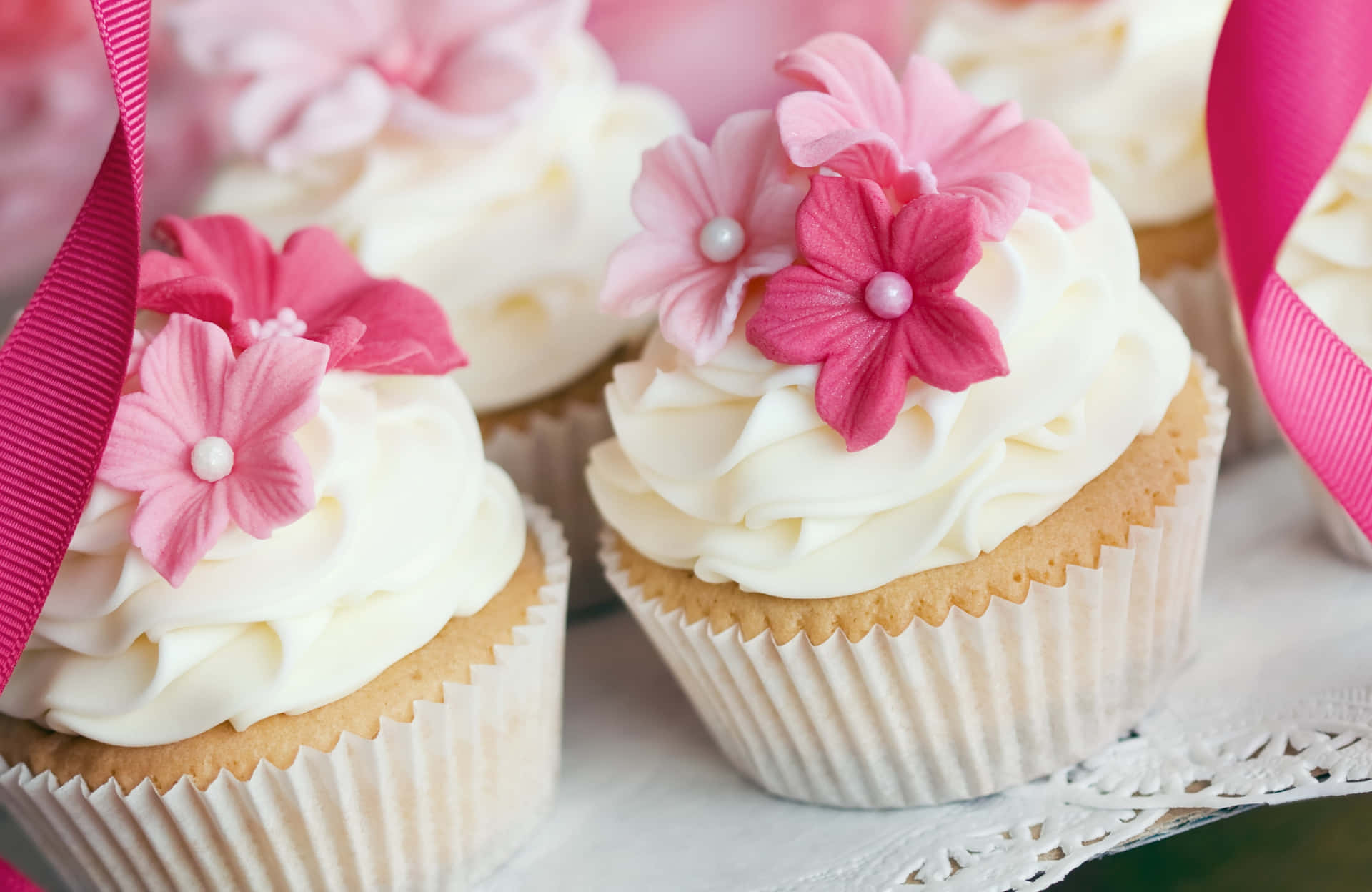 Delicious Pink Cupcakes with Whipped Cream and Cherry on Top Wallpaper