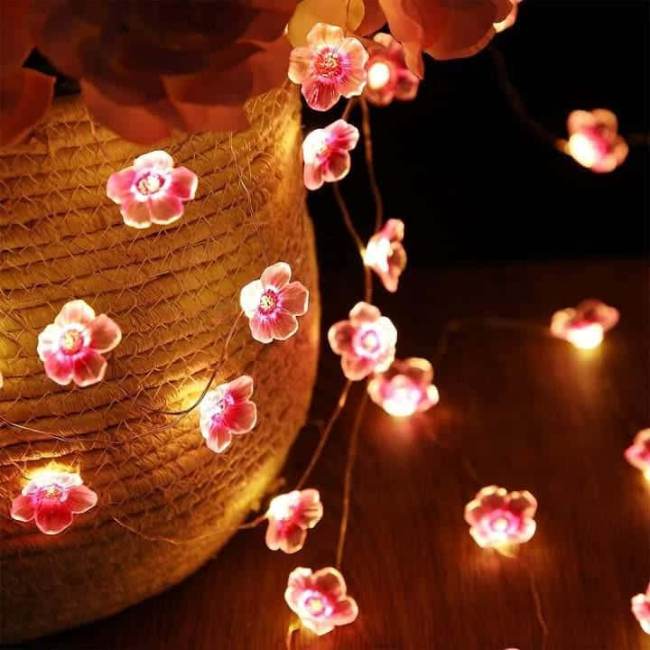 A Vase With Pink Flowers And Lights Wallpaper