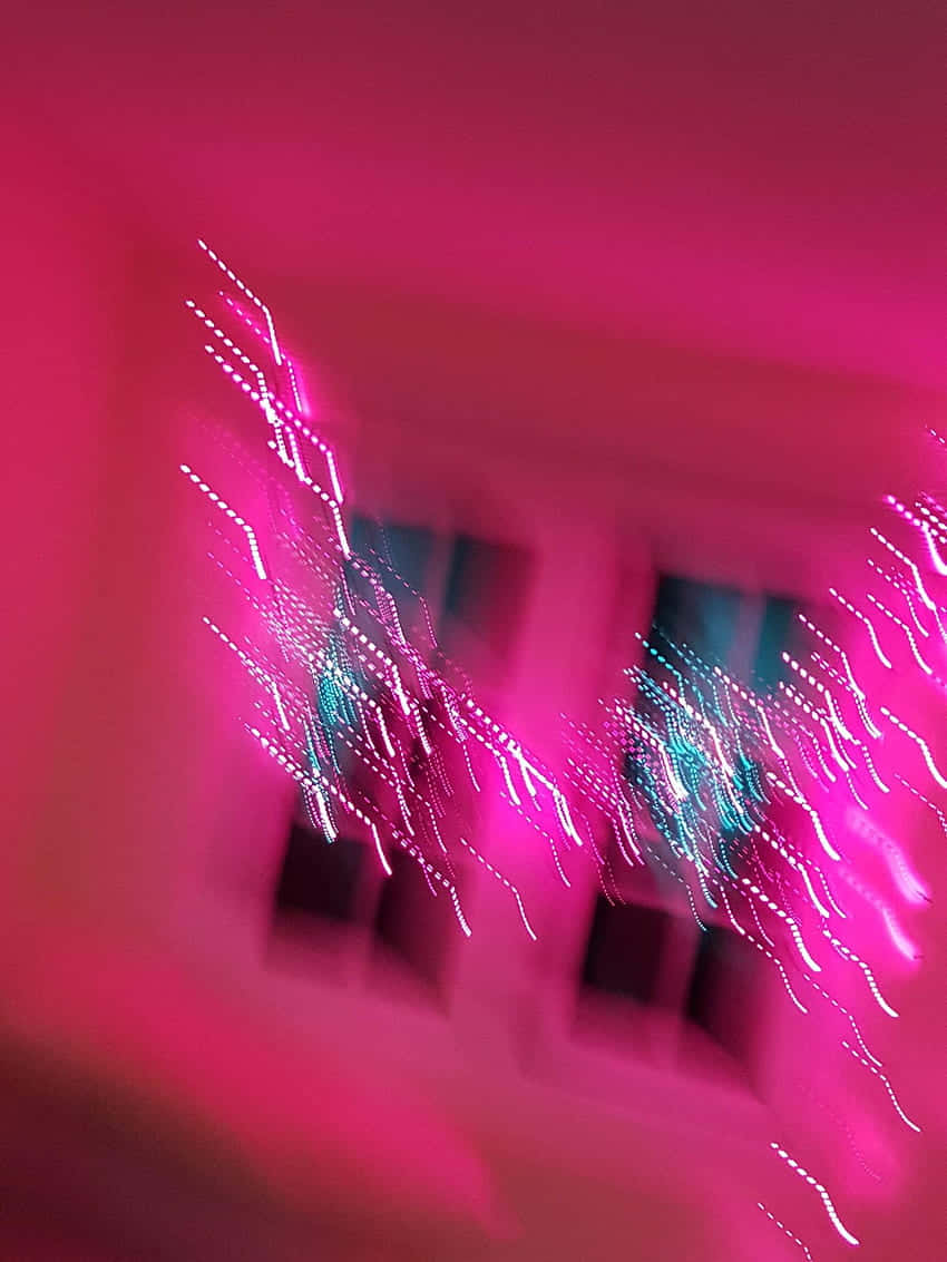 A Blurry Image Of A Pink Light In A Room Wallpaper
