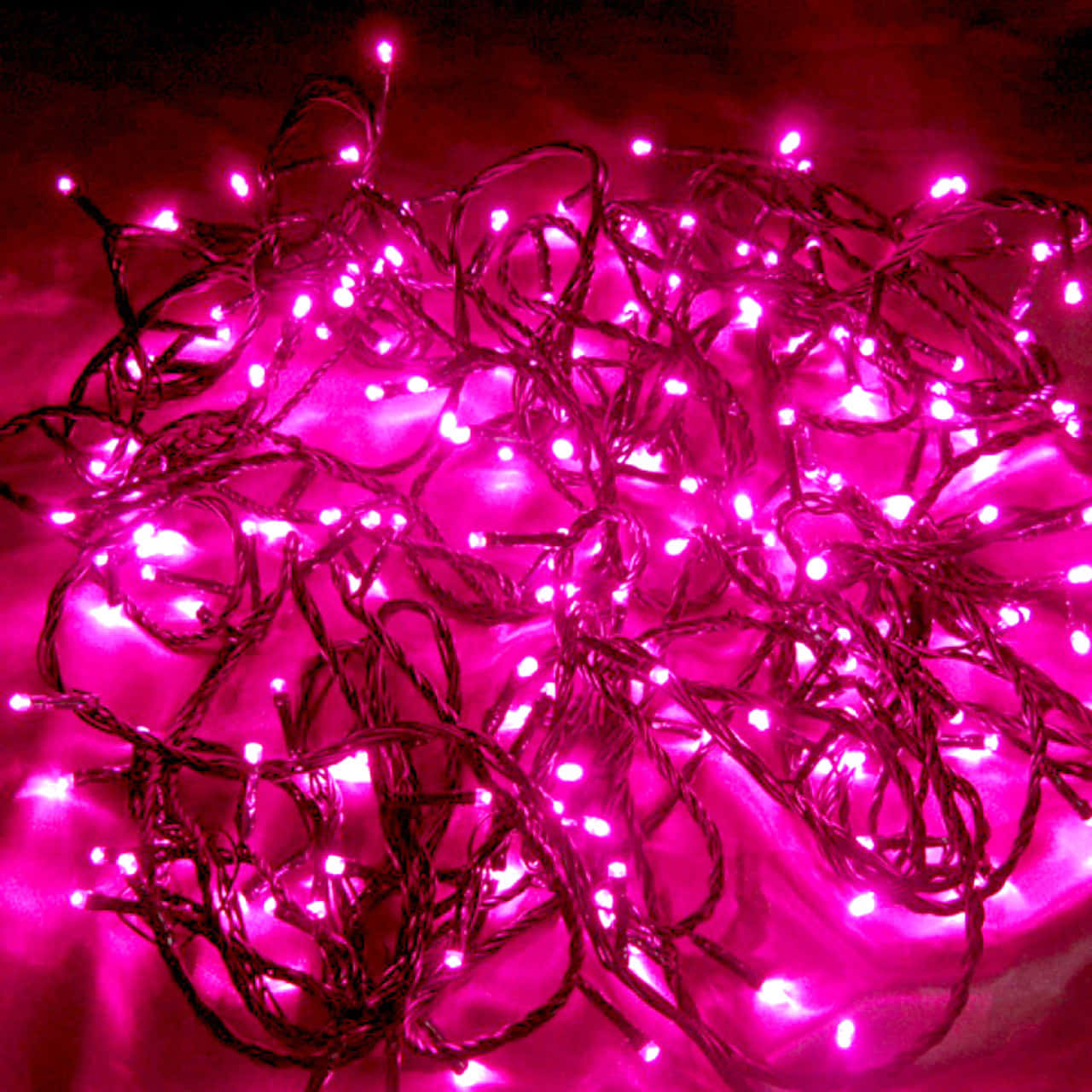 A string of pink fairy lights draped across a room creates a magical, warm ambience. Wallpaper