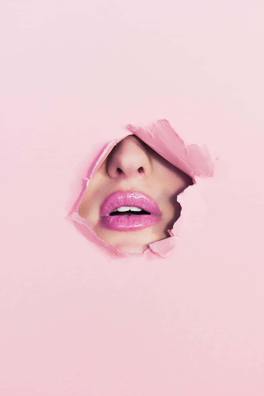 Gorgeous woman applying stunning pink lipstick Wallpaper