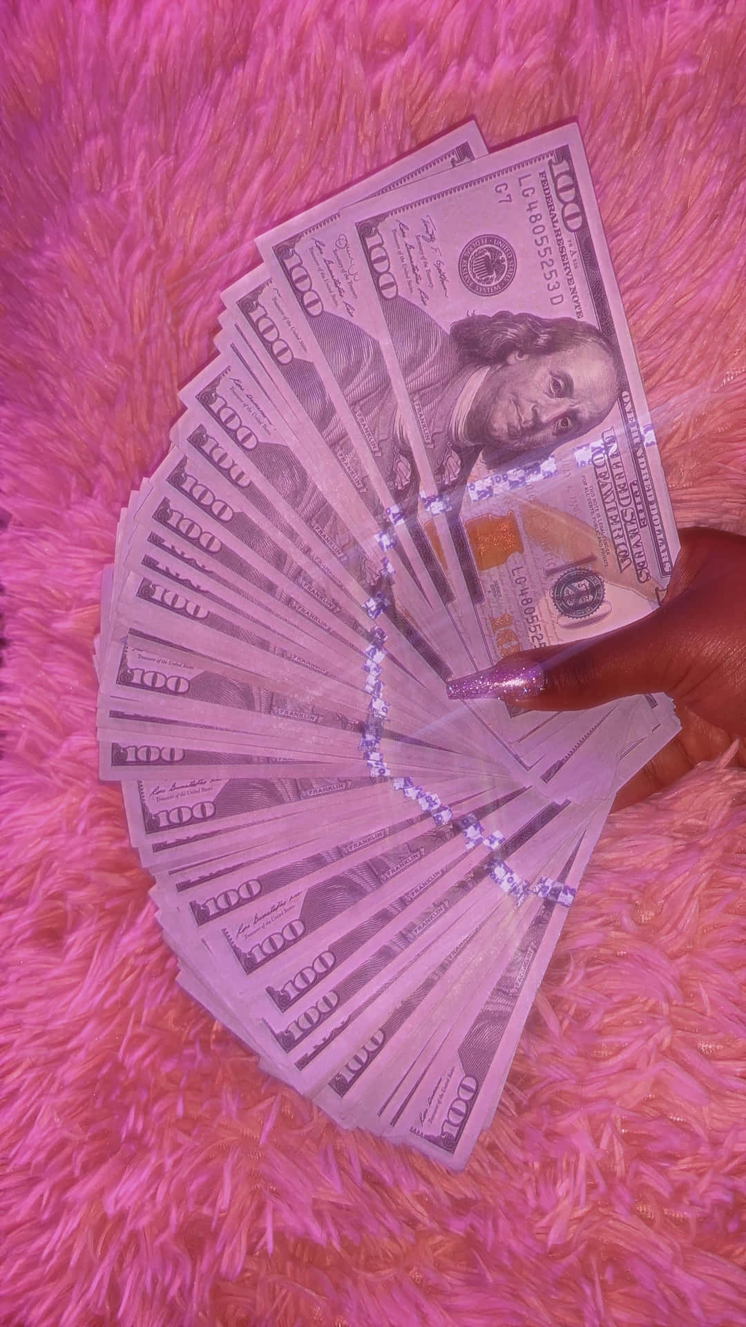 En person, der holder et pink dollar-sedel på en pink tæppe baggrund Wallpaper