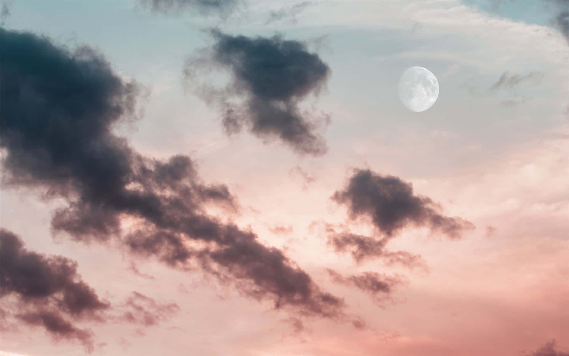 A Silhouetted Landscape Lit Up By A Pink Full Moon Wallpaper