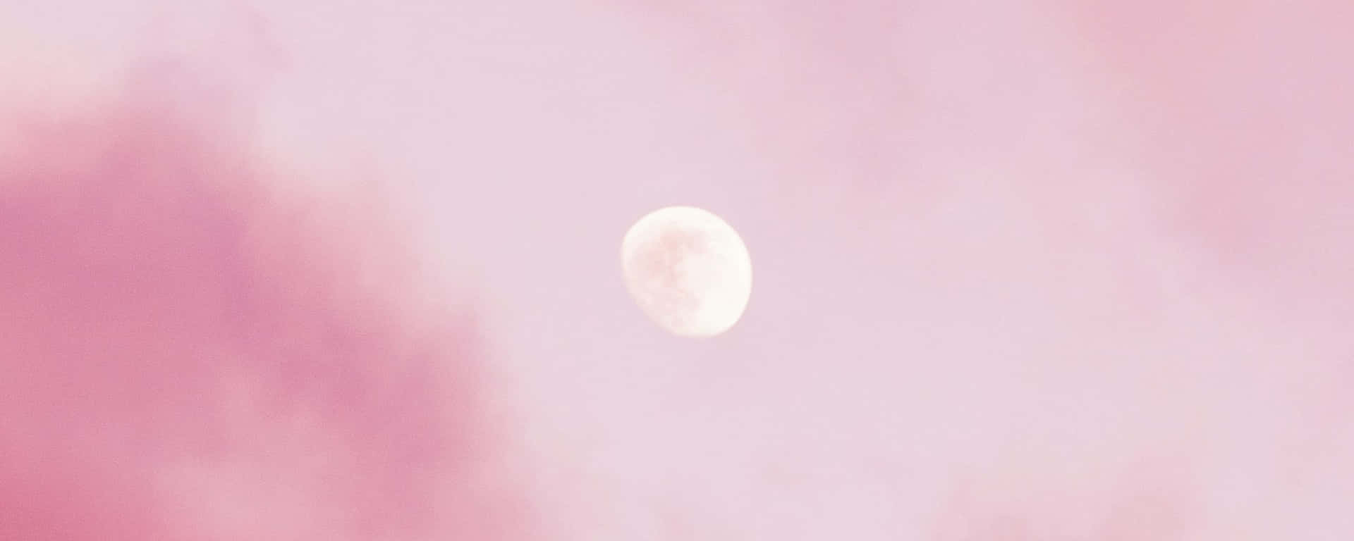 A Pink Moon In The Sky With Clouds Wallpaper