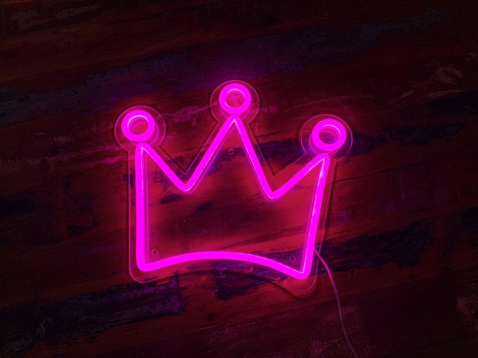 A Neon Crown Sign On A Wooden Floor Wallpaper