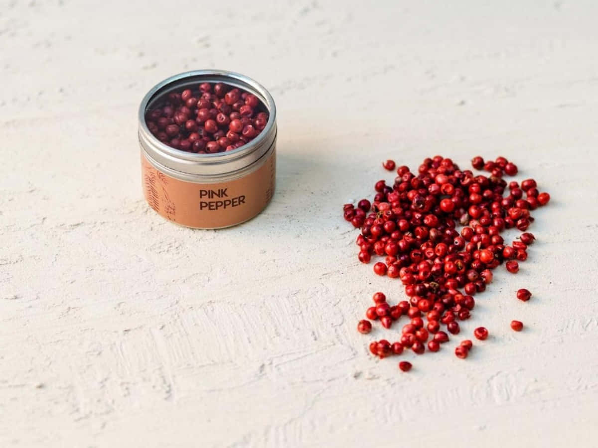 A close-up of pink peppercorns on a wooden spoon Wallpaper