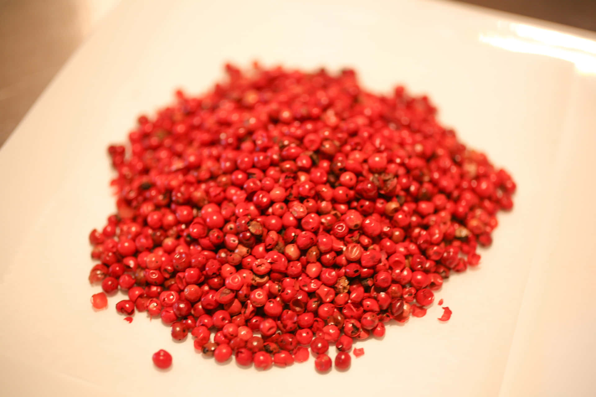 A close-up of Pink Peppercorns on a wooden surface Wallpaper
