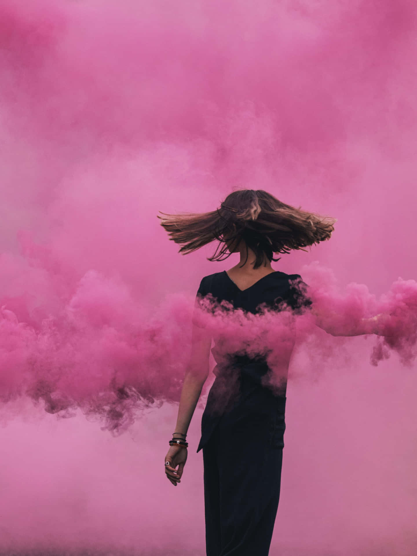 A Woman Walking Through Pink Smoke