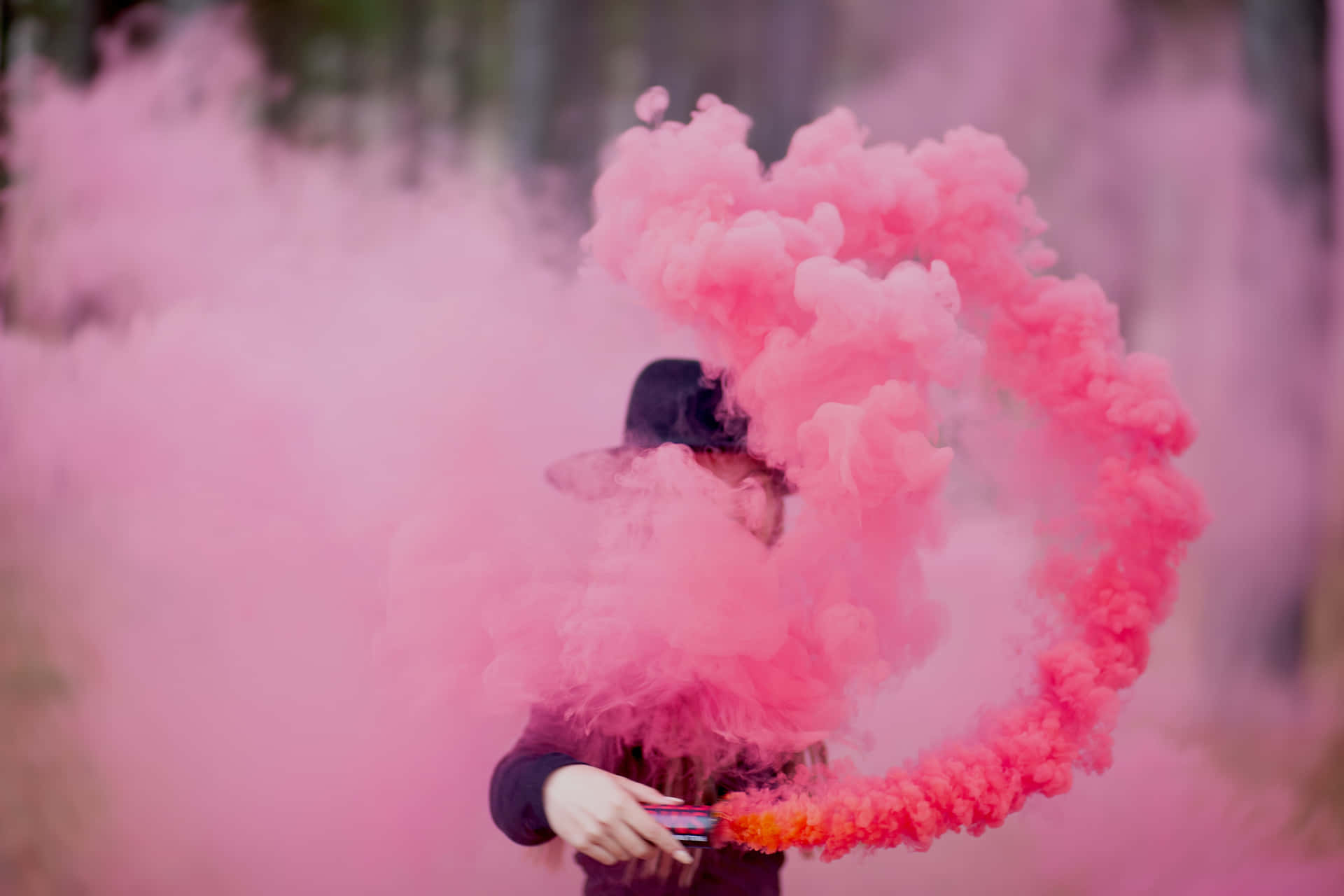 A Girl Is Holding Pink Smoke In Her Hands