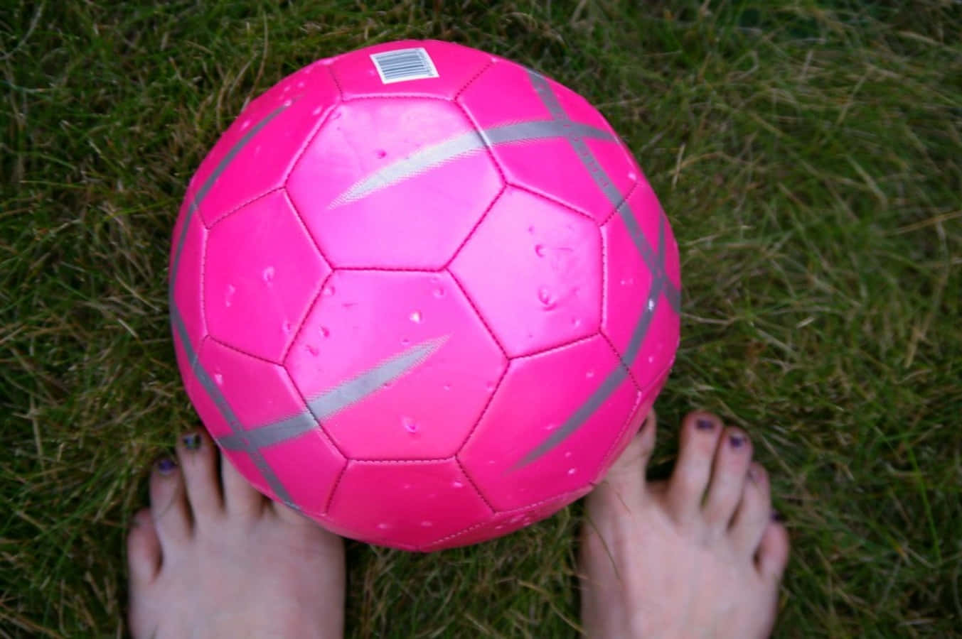 Unbalón De Fútbol Rosa Brillante En Un Campo De Césped. Fondo de pantalla