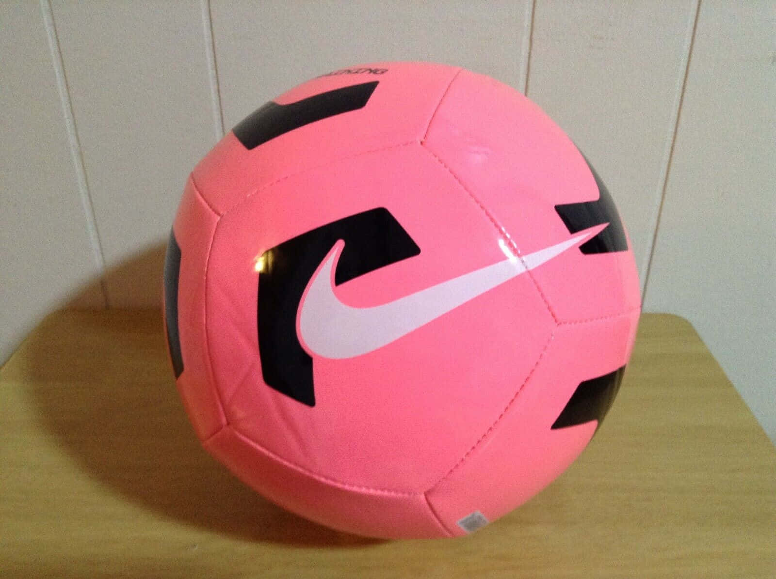 Balónde Fútbol Rosa Brillante Sobre Césped Verde Vibrante Fondo de pantalla