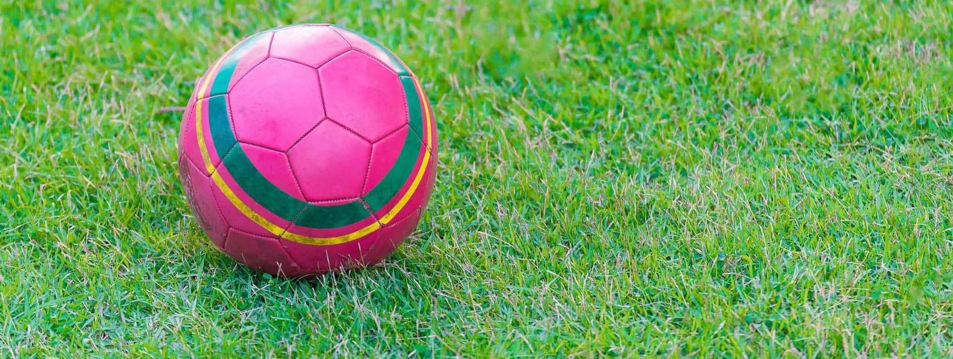 Balónde Fútbol Rosa Vibrante Sobre Césped Verde. Fondo de pantalla