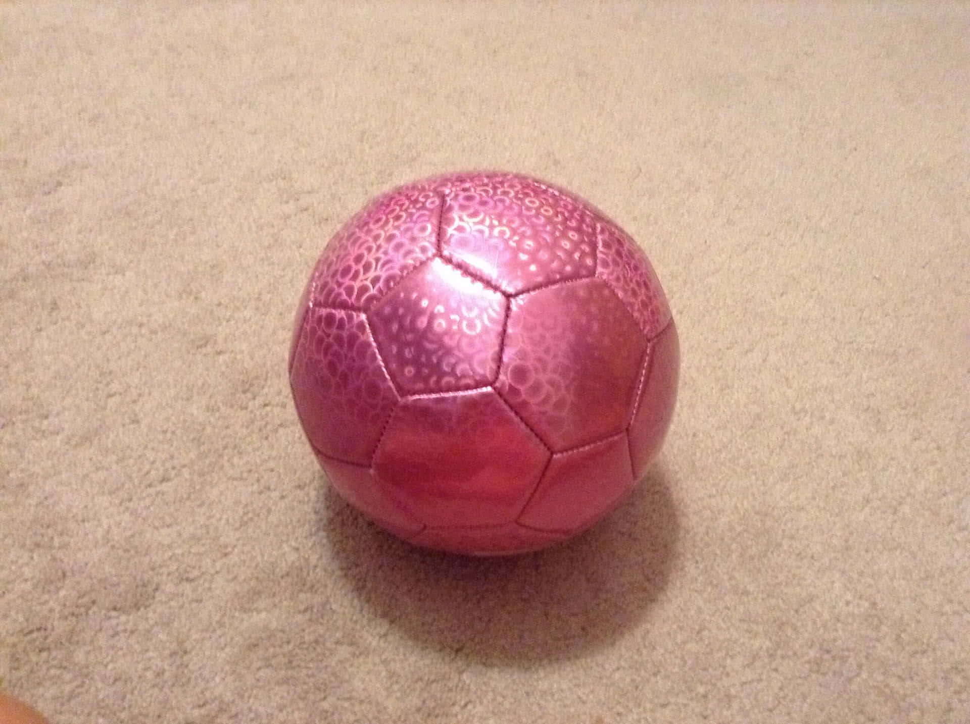 A pink soccer ball on a green grass field Wallpaper