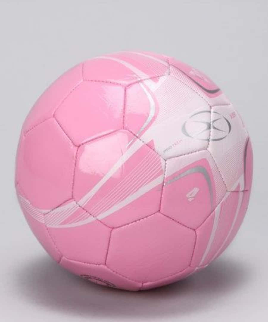 Unbalón De Fútbol Rosa Vibrante En Un Campo De Césped. Fondo de pantalla