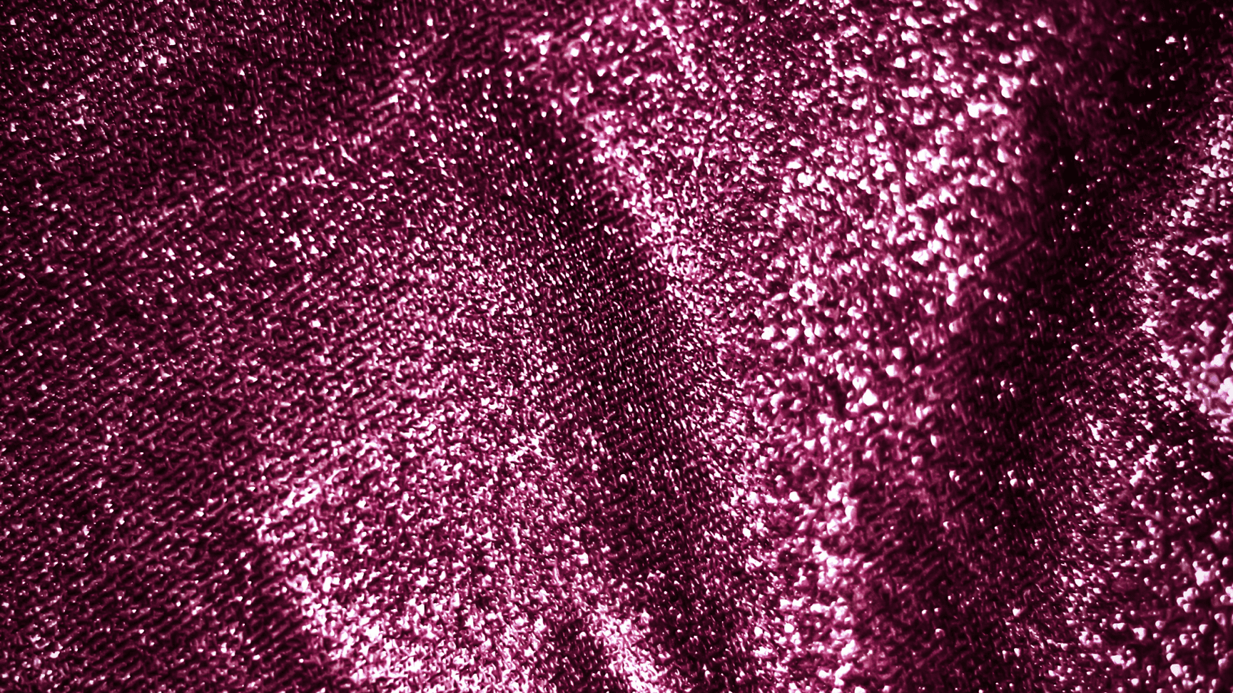 Abstract pink sparkles of light dance against a solid background