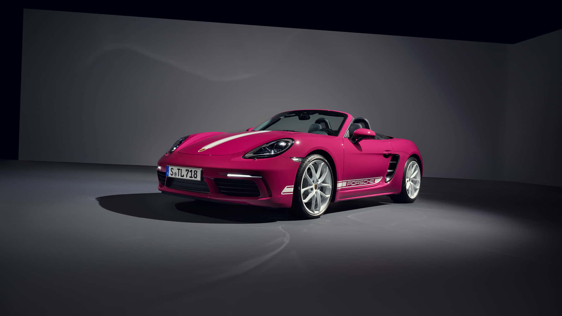 Porscheboxster: Un Coche Deportivo Rosa En Una Habitación Oscura. Fondo de pantalla