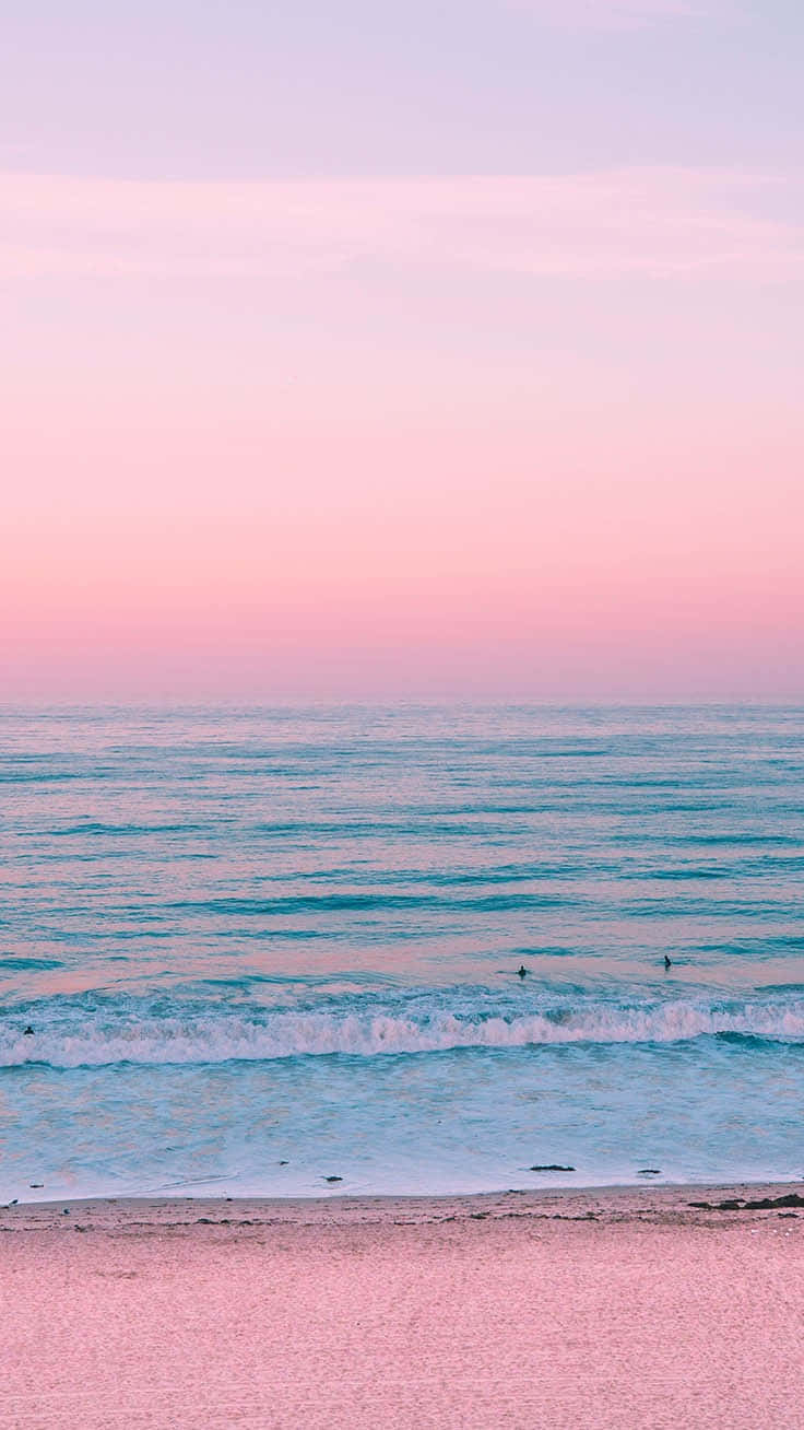 En pink solnedgang på stranden med et surfbræt Wallpaper