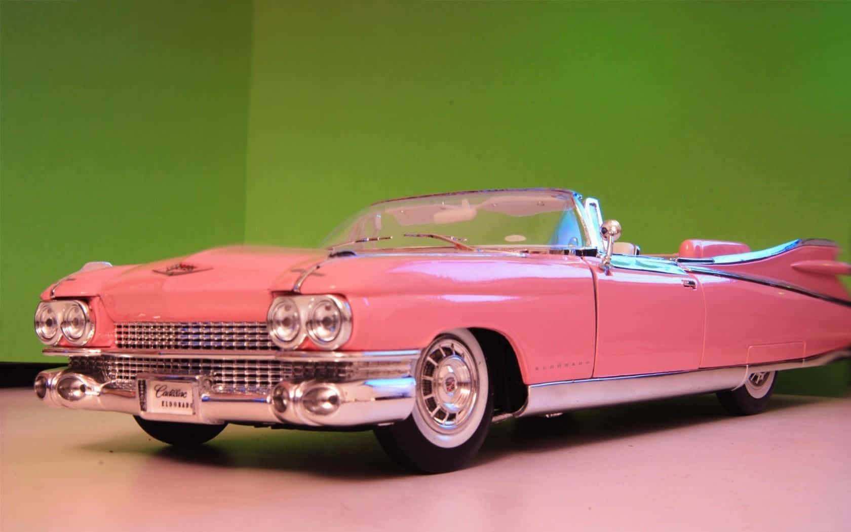 A Pink Cadillac Convertible Is On Display Wallpaper