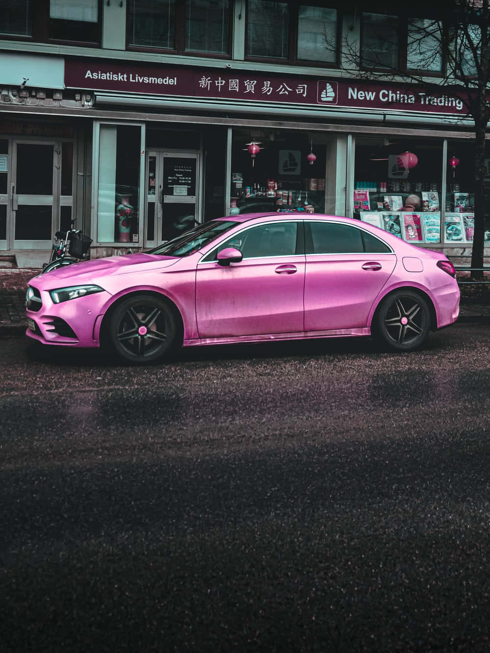 A Pink Mercedes Cla Parked In Front Of A Building Wallpaper
