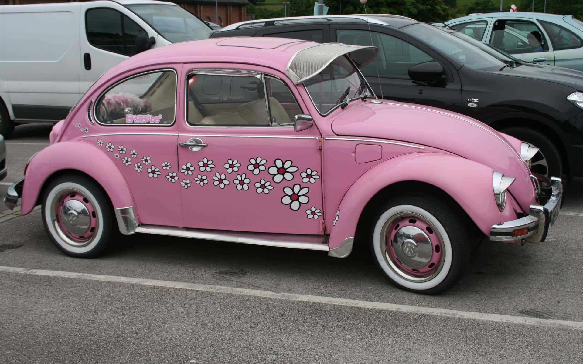 En pink Volkswagen Beetle parkeret på en parkeringsplads Wallpaper