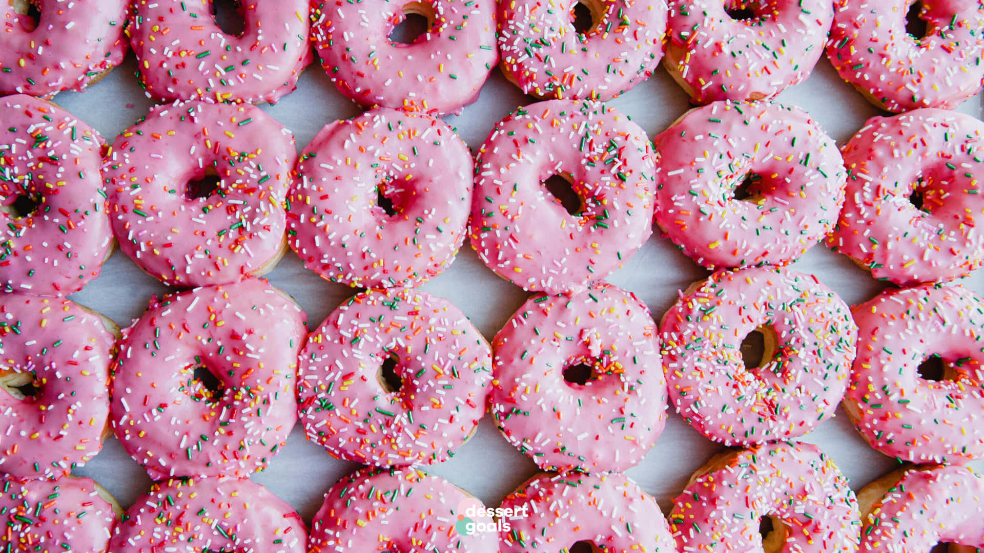 A Bunch Of Pink Sprinkled Donuts