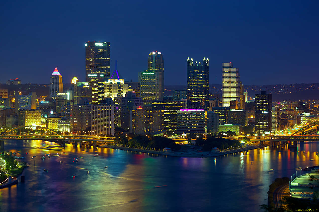 Panoramadel Skyline Di Pittsburgh Di Notte Sfondo