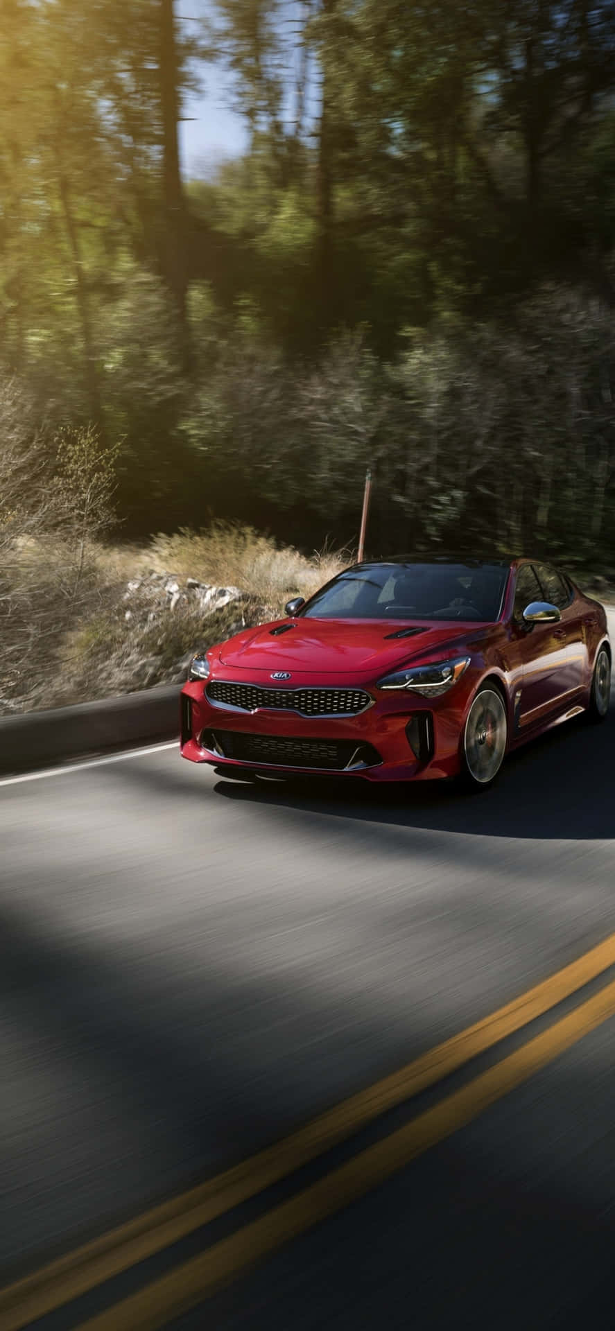 The Red Kia Stinger Driving Down A Road