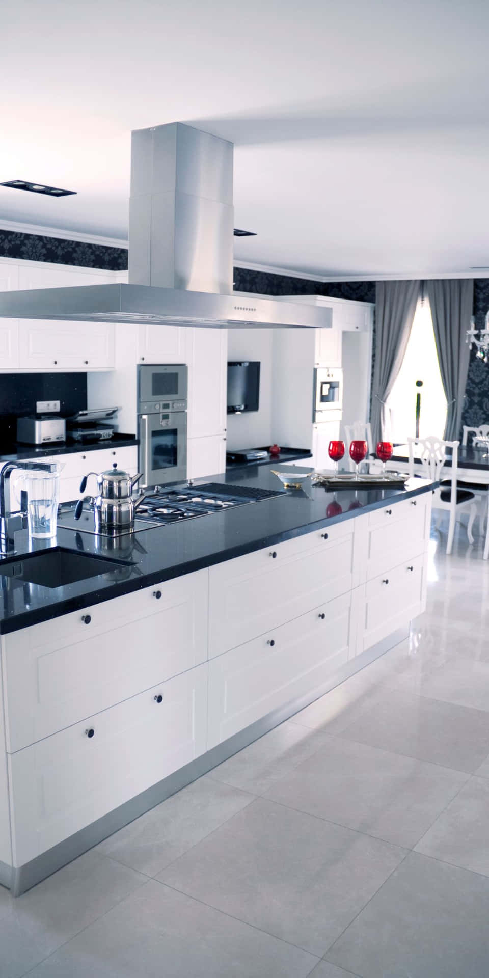 A White Kitchen With Black Counter Tops And A Black Stove