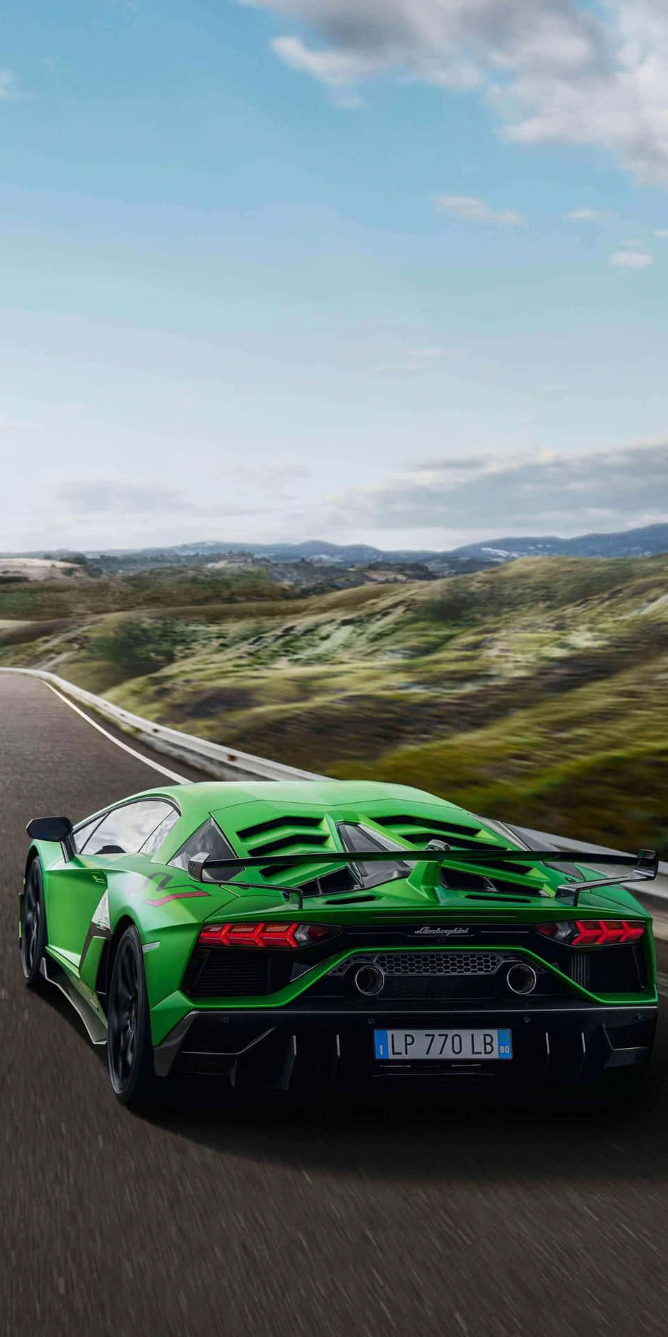 The Green Lamborghini Huracan Is Driving Down The Road