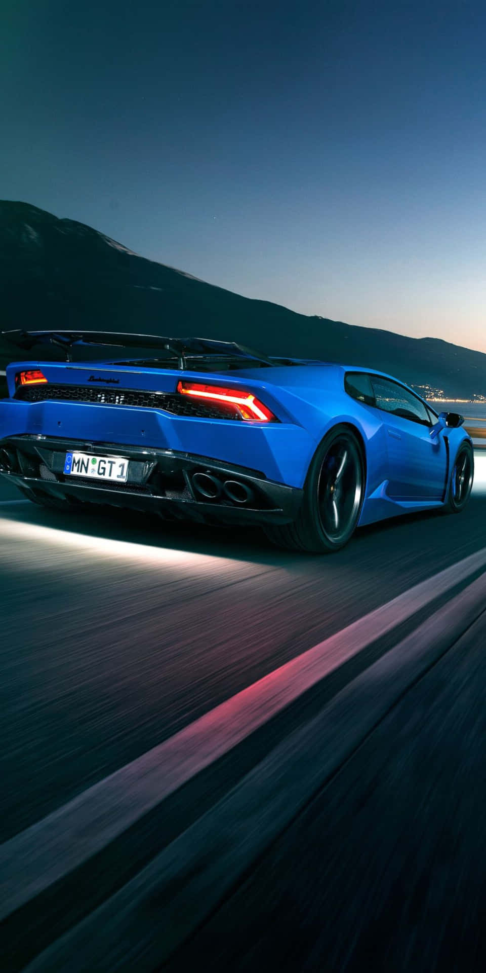The Blue Lamborghini Huracan Is Driving Down The Road