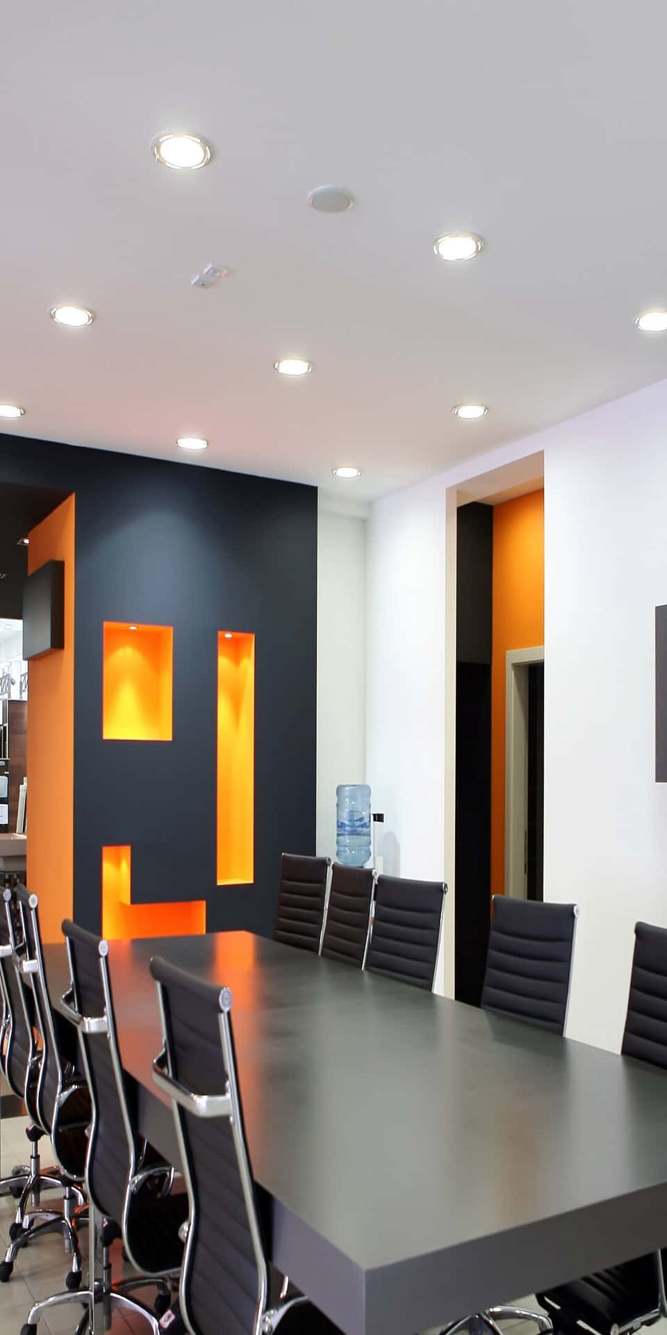 A Conference Room With Orange Walls And Black Chairs
