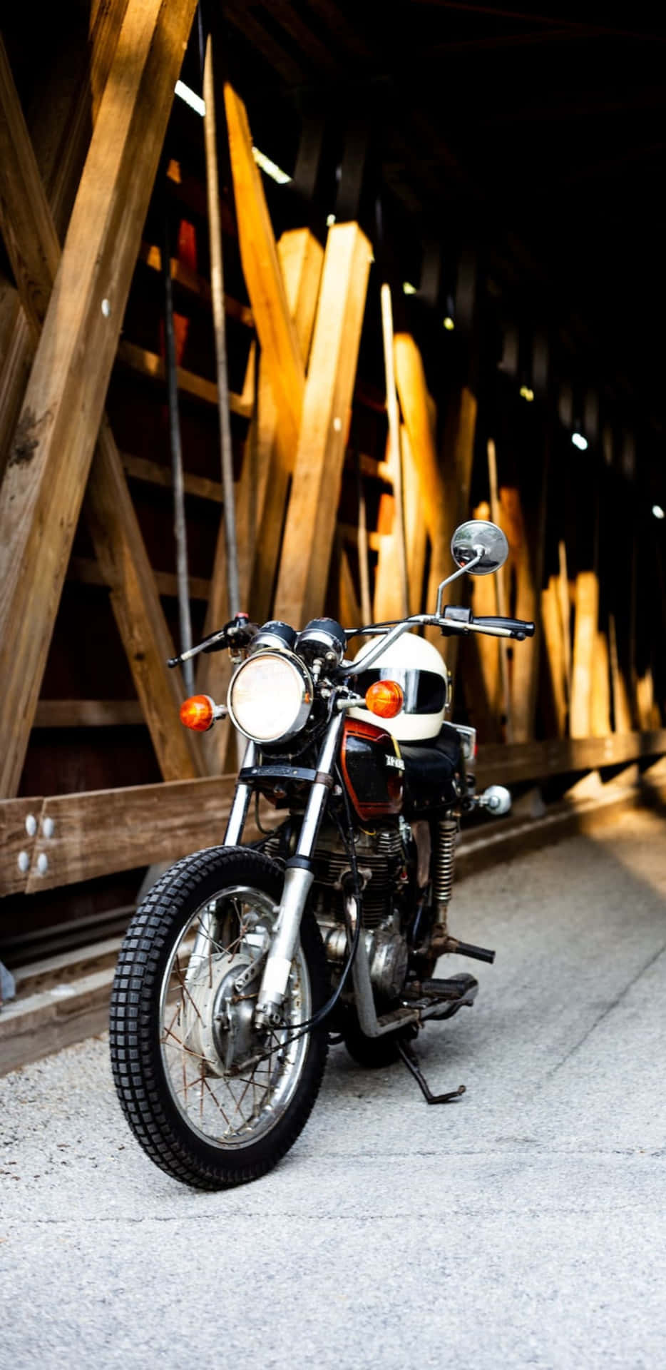 A Motorcycle Parked Under A Wooden Bridge