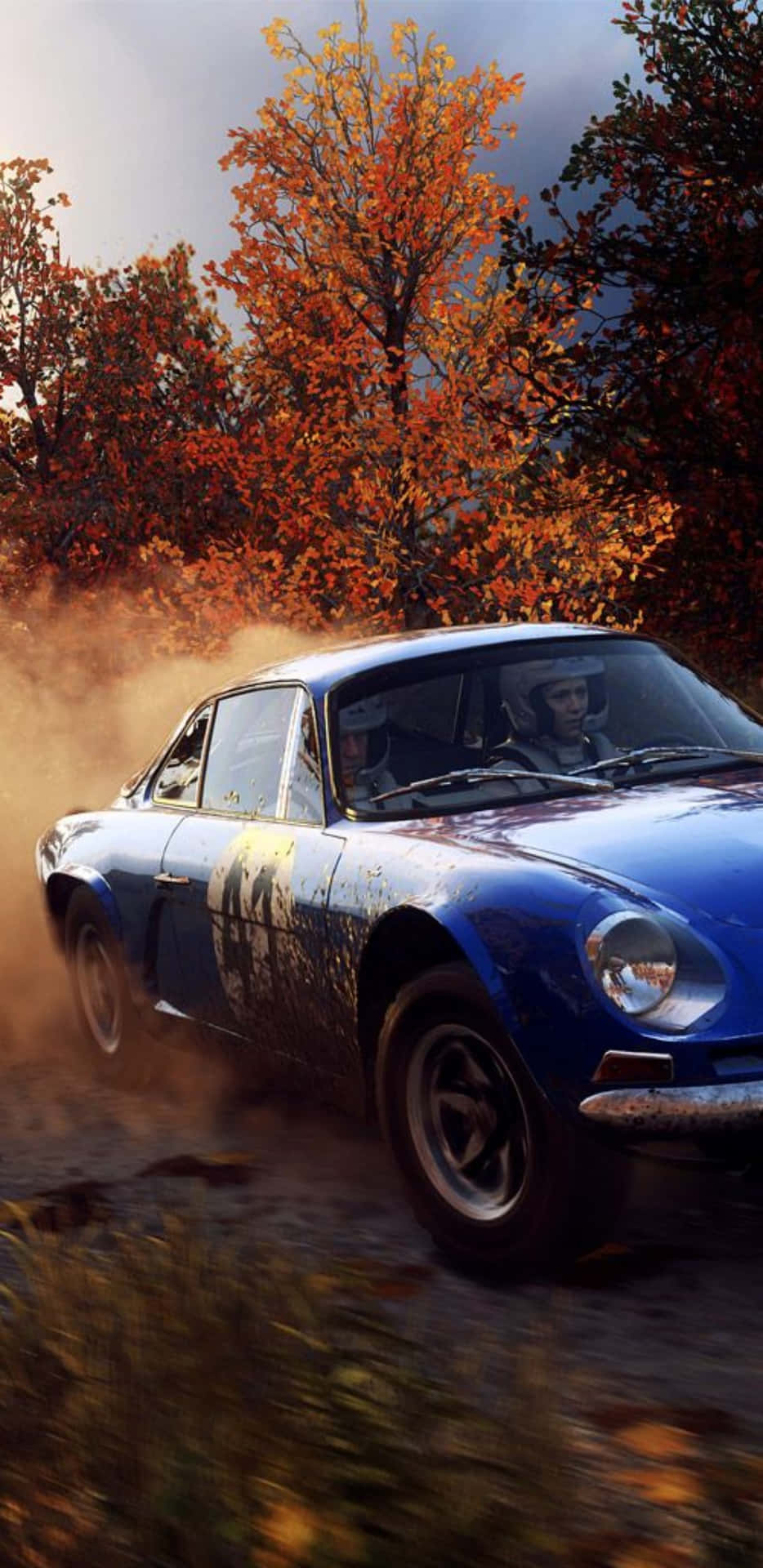 A Blue Car Driving Through A Dirt Road