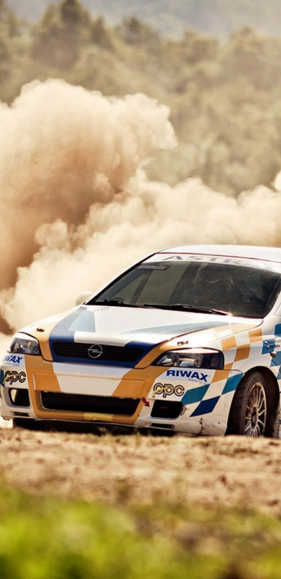 A Rally Car Driving Through A Dusty Field