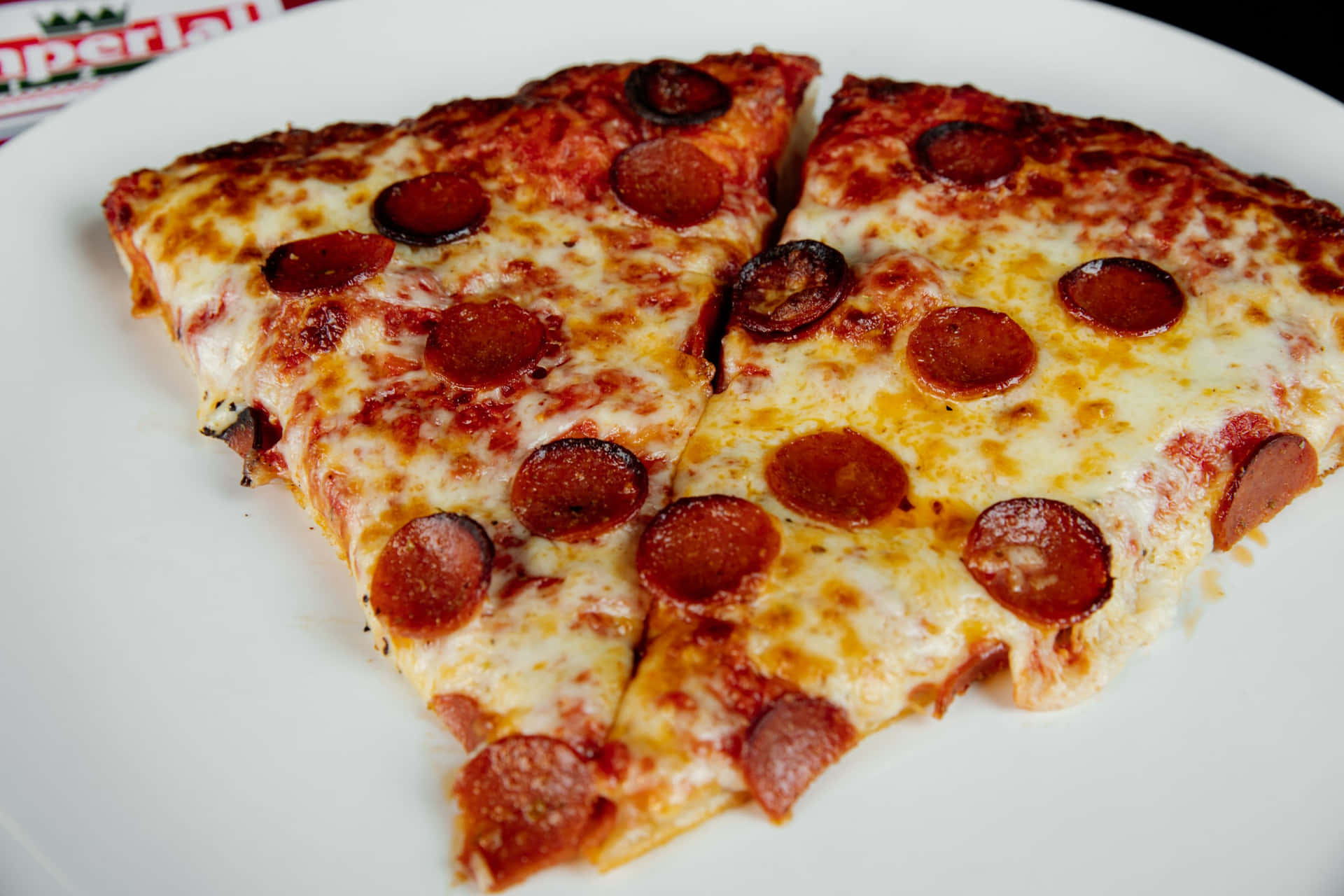 Immaginedi Due Fette Di Pizza Con Pepperoni Sul Piatto.